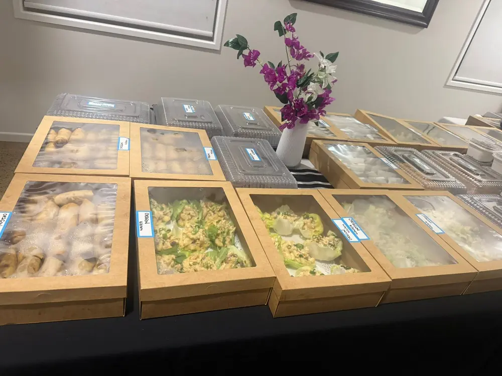 Boxed catering dishes arranged across a function table
