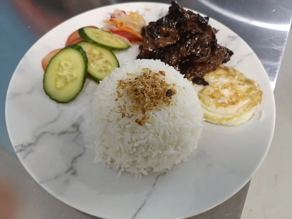 Plate of rice, grilled meat, egg and fresh cucumber